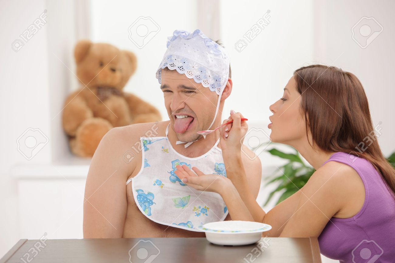 Big Bebe Manger Jeune Femme Alimentant Un Homme Adulte Infantile Dans Le Bebe Couvre Chefs Banque D Images Et Photos Libres De Droits Image