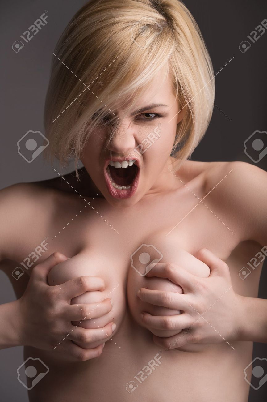 Naked Emotions. Beautiful Young Woman Holding Her Breast In Hands And  Shouting While Isolated On Grey Stock Photo, Picture and Royalty Free  Image. Image 21986236.