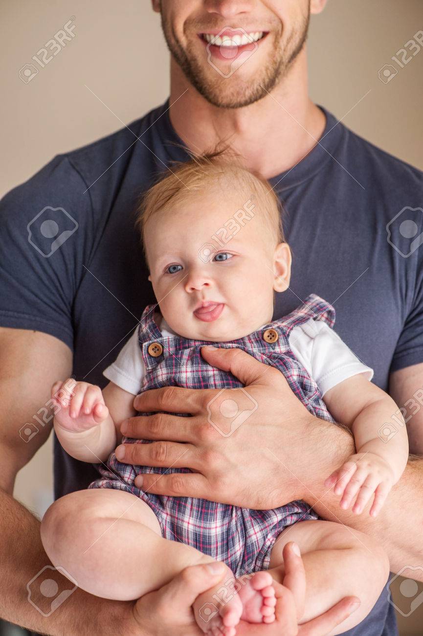 Man With Baby Young Muscular Man Holding Baby In His Hands And Smiling Stock Photo Picture And Royalty Free Image Image