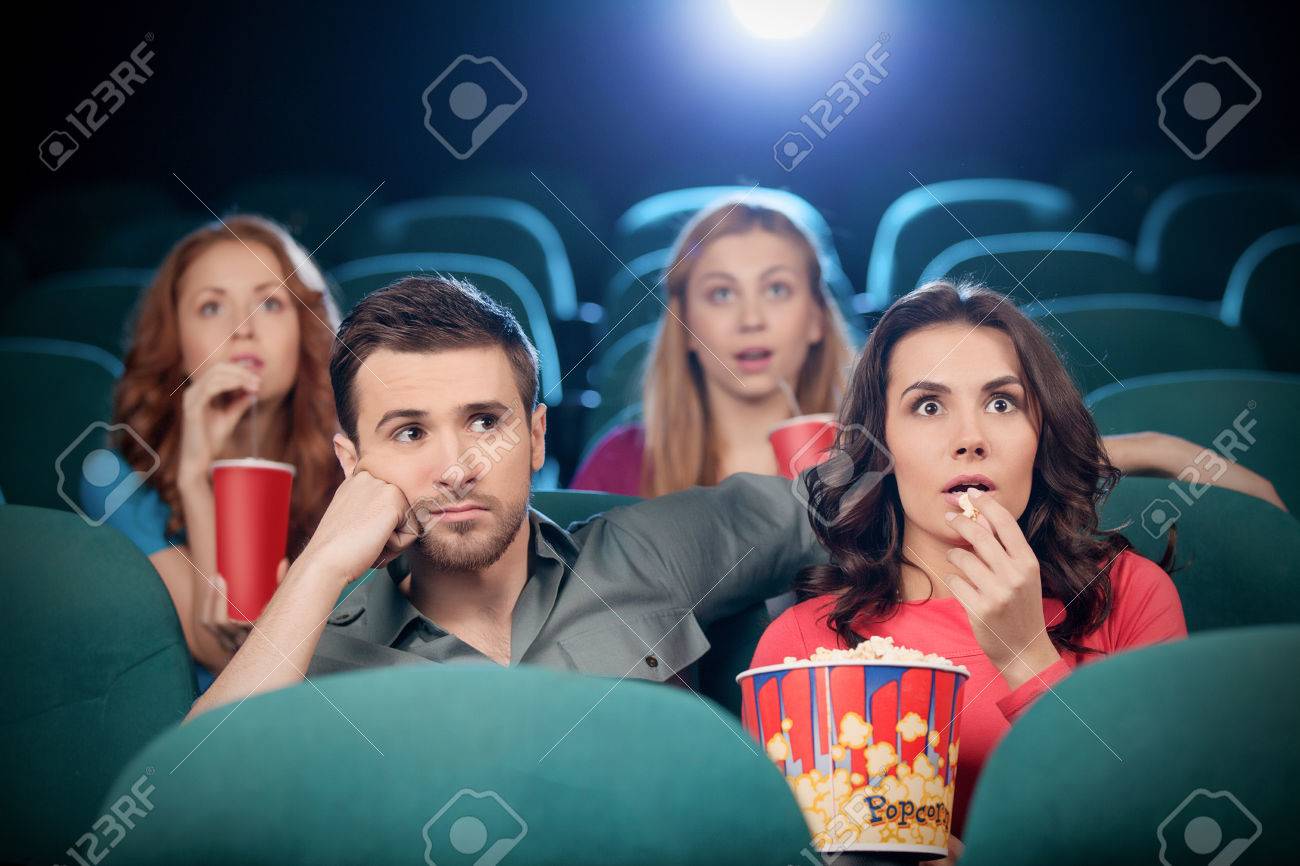 映画館でのカップル 退屈男性と映画館で映画を見て興奮している女性 の写真素材 画像素材 Image