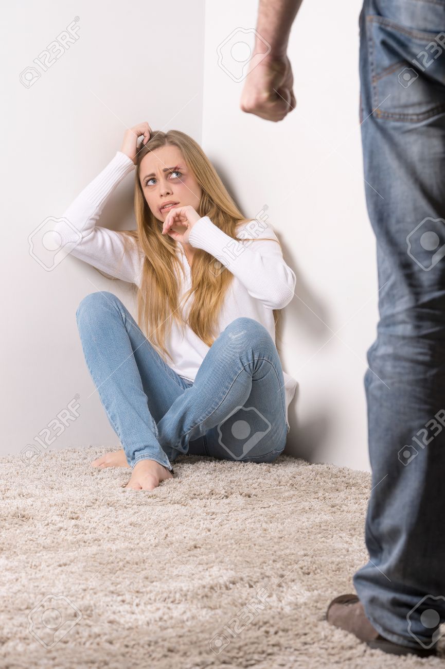 Scared Young Woman Hiding In A Corner From Aggressive Man. Female Face With  Bruise Stock Photo, Picture and Royalty Free Image. Image 23473937.