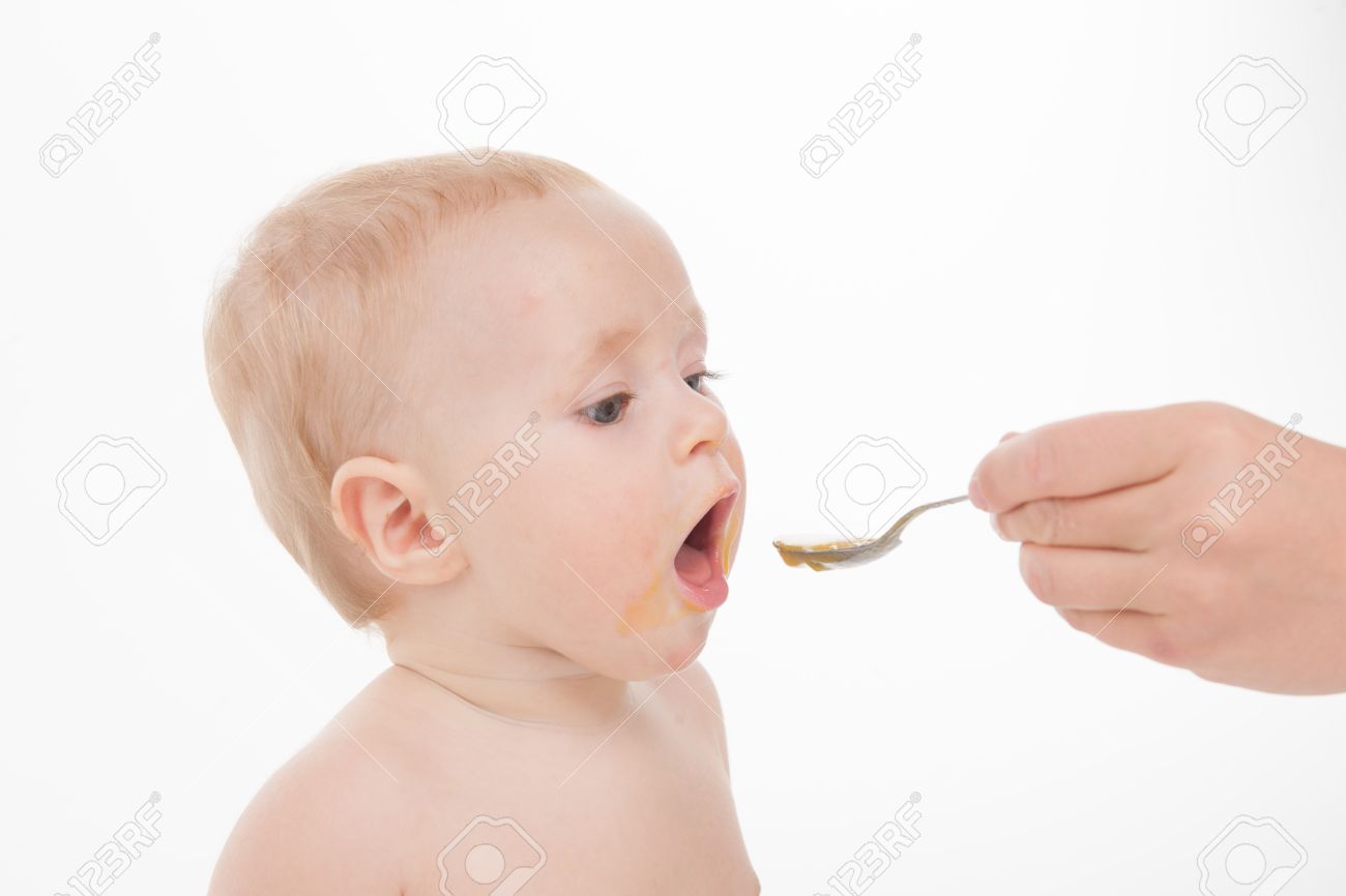 かわいい赤ちゃん離乳食を食べるをクローズ アップ 赤ちゃんの顔を汚いし 白い背景で隔離の手の母 の写真素材 画像素材 Image