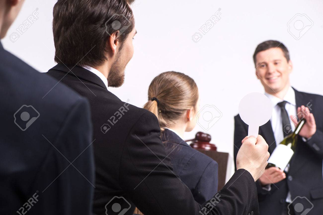 handsome man holding bottle of wine. person selling expensive drinks at auction - 27750386 handsome man holding bottle of wine. person selling expensive drinks at auction - 27750386