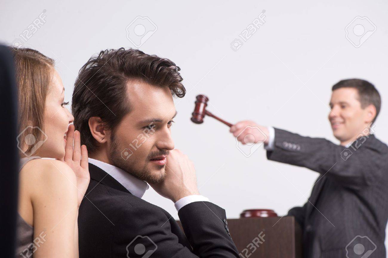 young beautiful brunette whispering into ear. handsome man listening to woman at auction - 27750389 young beautiful brunette whispering into ear. handsome man listening to woman at auction - 27750389