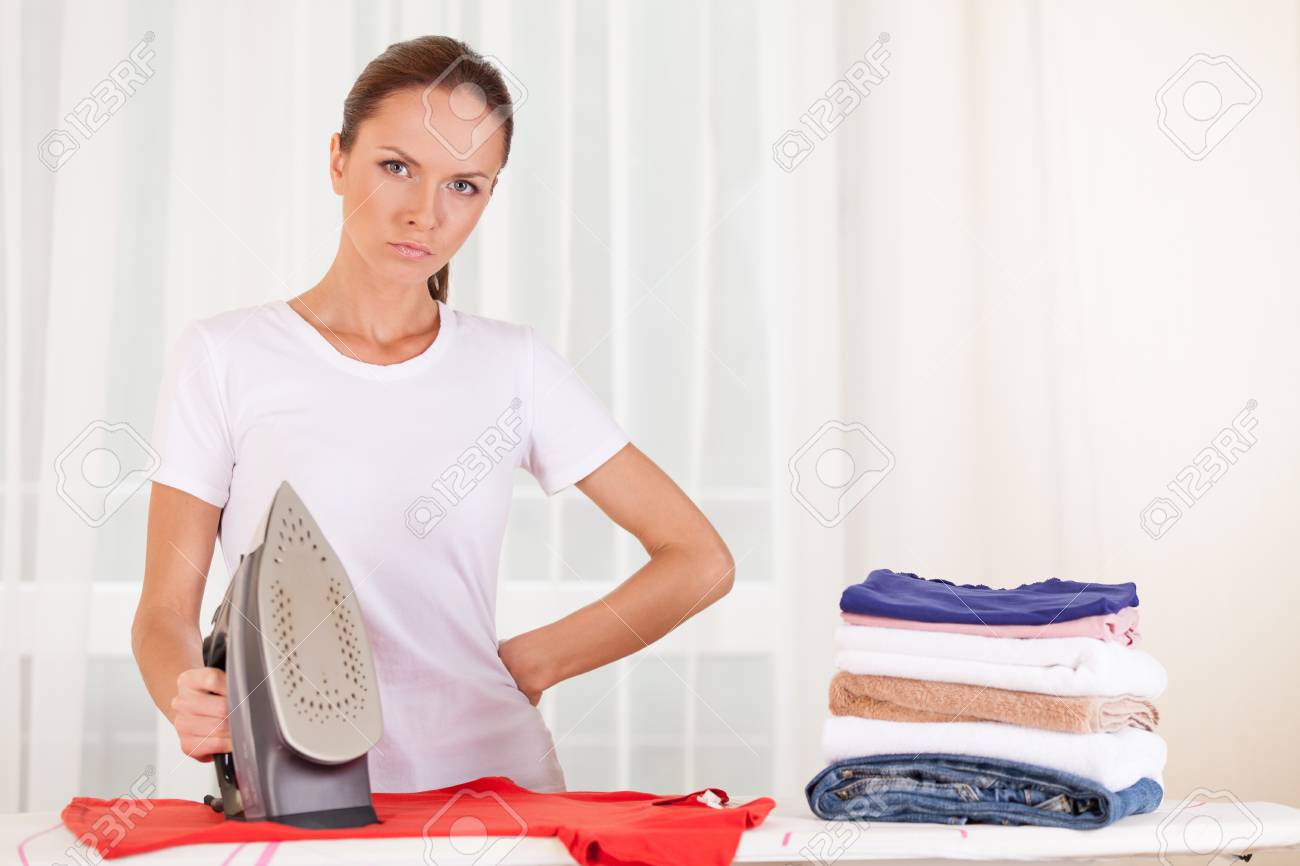 Portrait Of Serious Housewife Ironing
