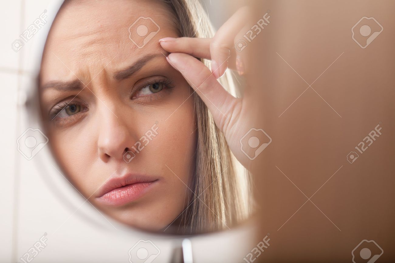 closeup of young woman looking into mirror. mirror reflection of beautiful girl eyebrow - 28561897 closeup of young woman looking into mirror. mirror reflection of beautiful girl eyebrow - 28561897