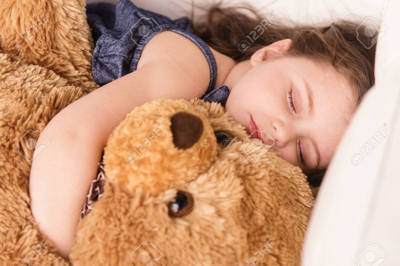 little girl hugging teddy bear