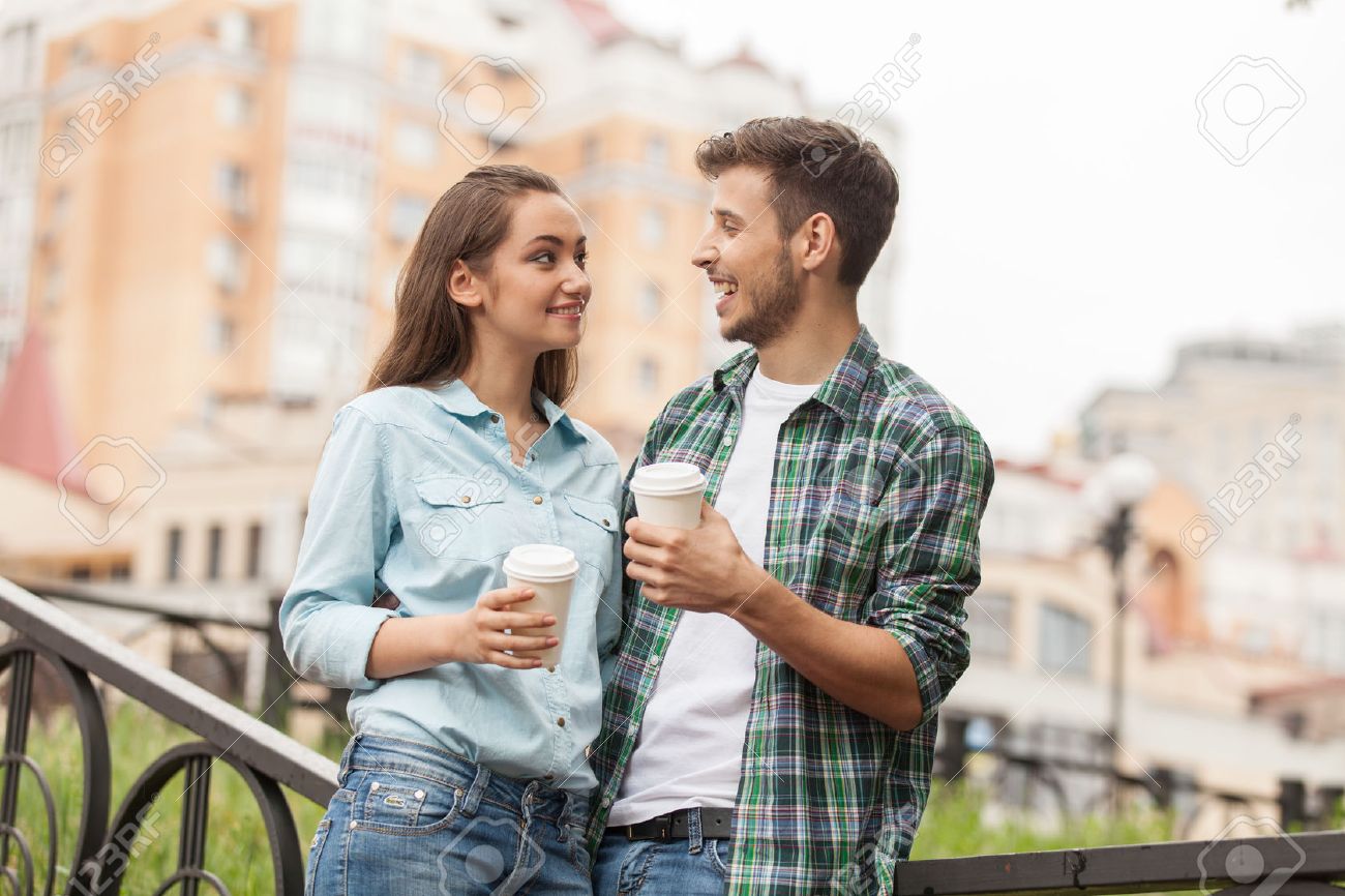 Young couple drinking coffee outside. Portrait of happy partners having break outside at summer - 31807745 Young couple drinking coffee outside. Portrait of happy partners having break outside at summer - 31807745