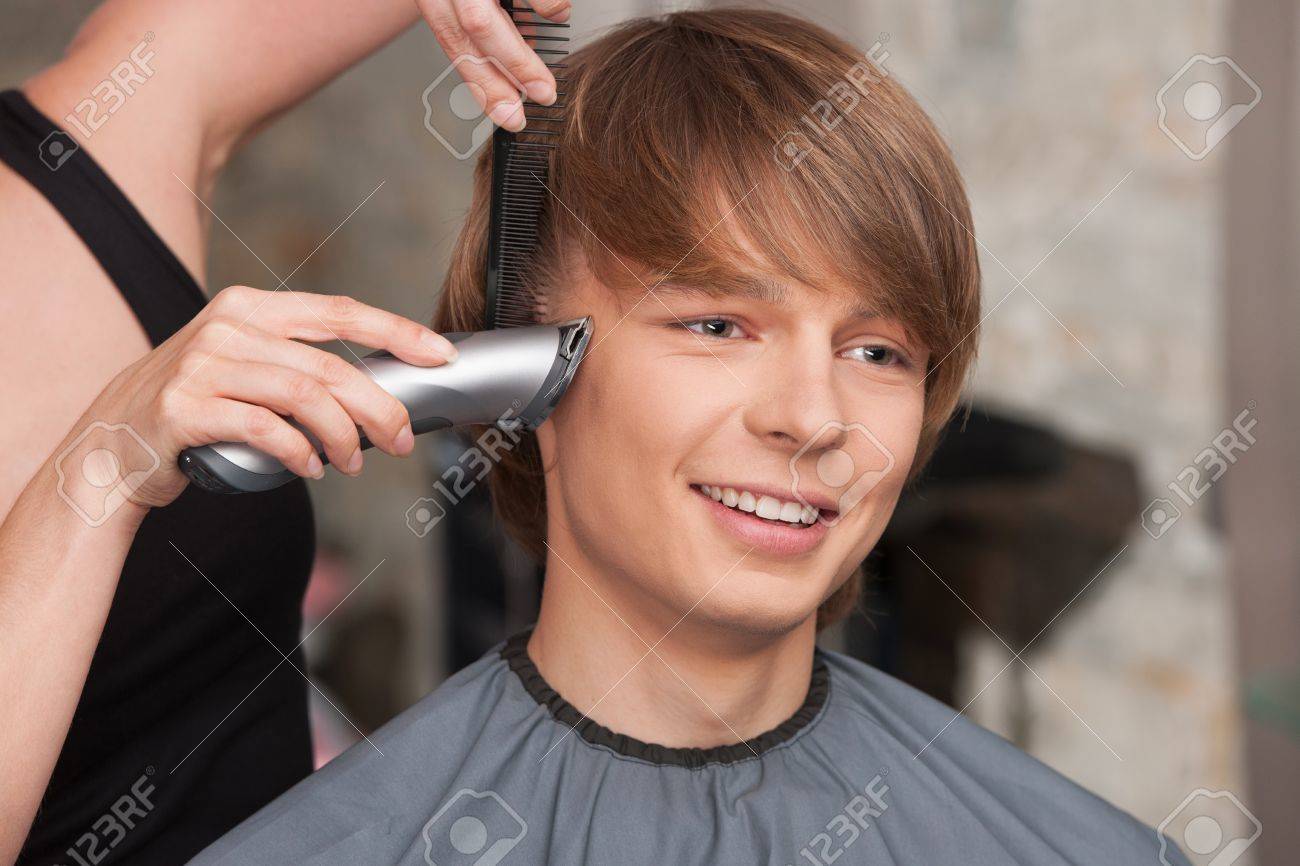 Female Hairdresser Cutting Hair Of Man Client Using Trimmer