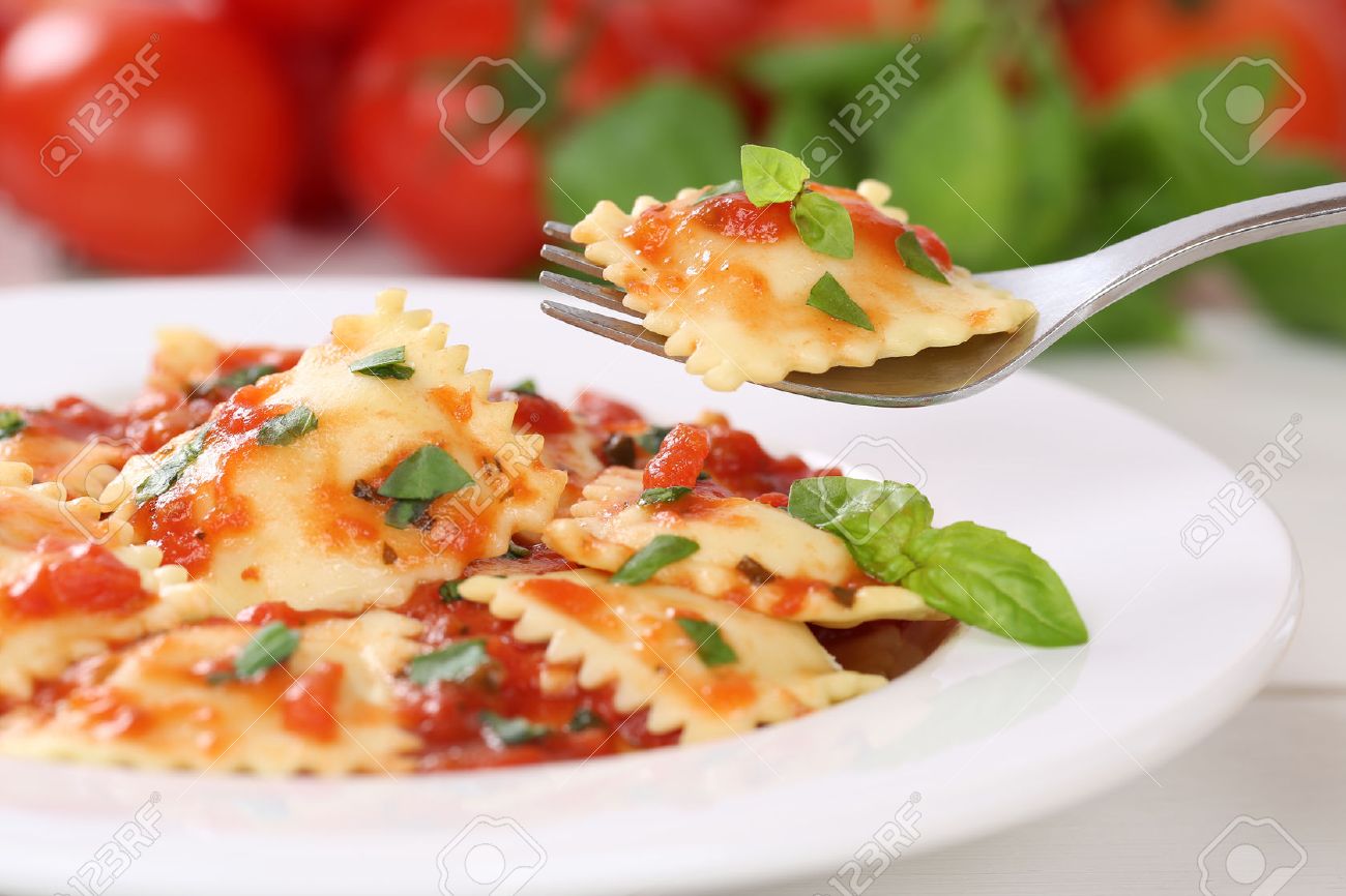 Eating Italian Pasta Ravioli with tomato sauce noodles meal with basil on a plate - 38009181 Eating Italian Pasta Ravioli with tomato sauce noodles meal with basil on a plate - 38009181