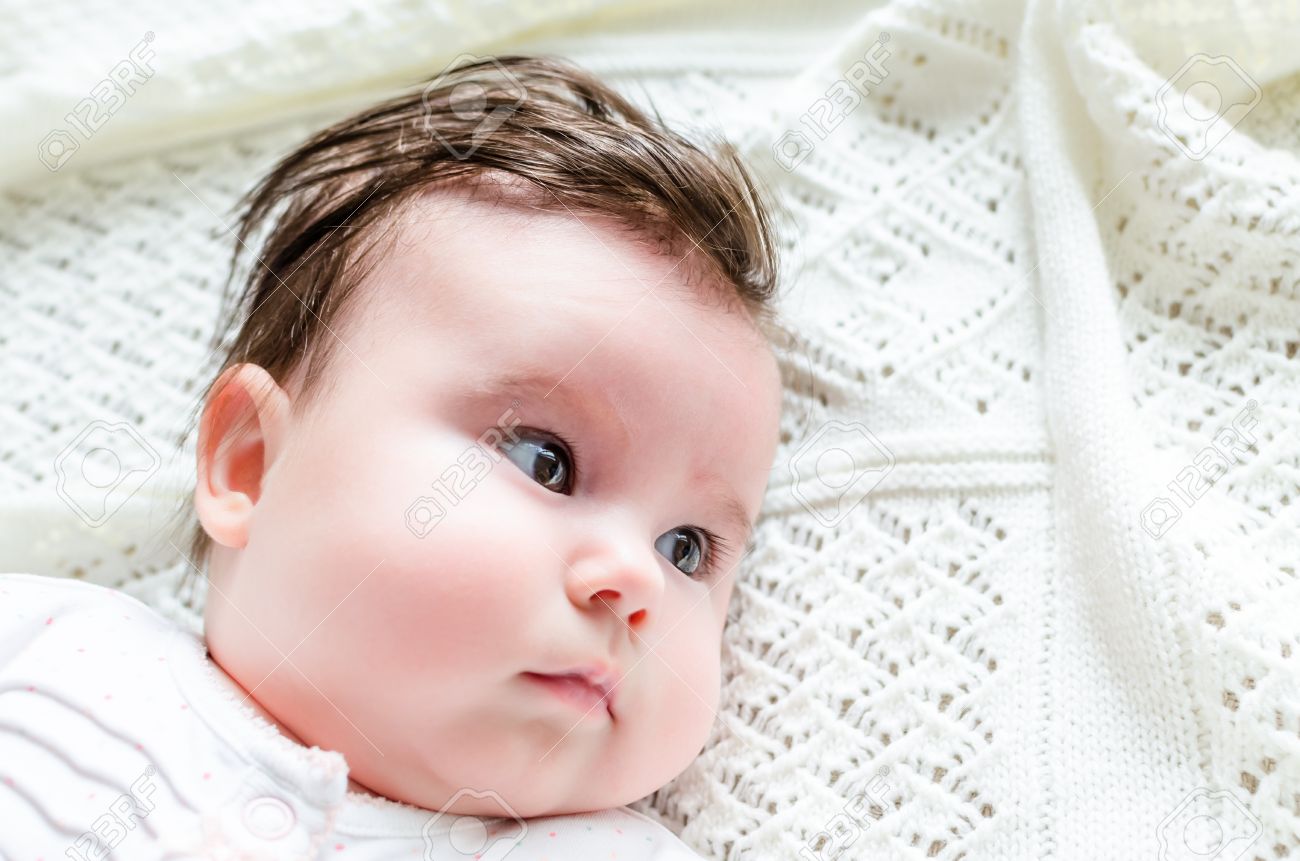 Portrait De Doux Mignon Petit Bebe Nouveau Ne Fille Aux Cheveux Brunette A Nice Blanc Repere Barboteuse Regardant Avec De Grands Yeux Noisette Belle Couche Sur Blanc Couverture De Laine Sur Un Lit