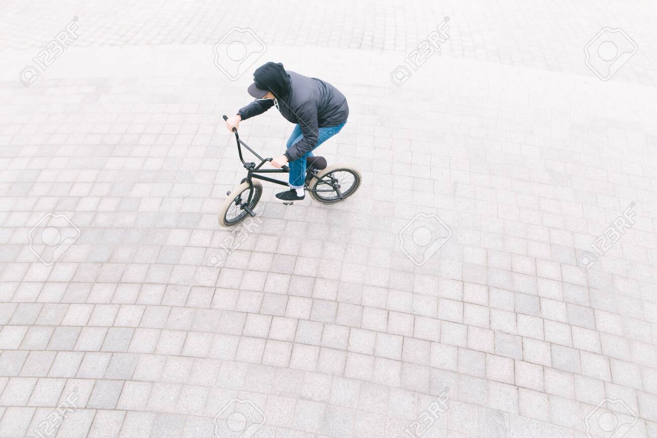 男は舗装の頭上でbmxバイクに乗ります 広場でbmxに乗るサイクリストのミニマリストの写真 の写真素材 画像素材 Image 男は舗装の頭上でbmxバイクに乗ります 広場でbmxに乗るサイクリストのミニマリストの写真 の写真素材 画像素材 Image