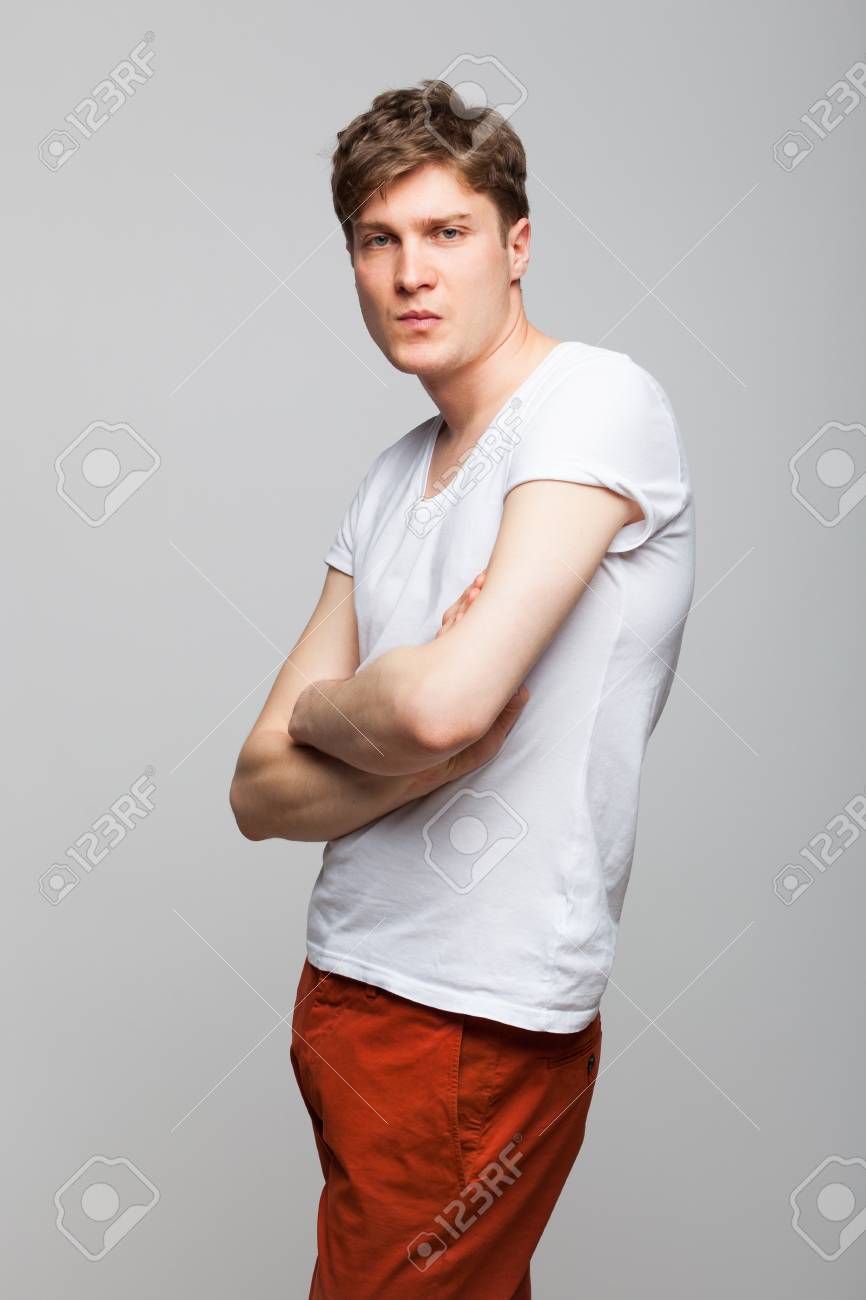 白い T シャツに灰色の背景に腕を組んで若い男 の写真素材 画像素材 Image