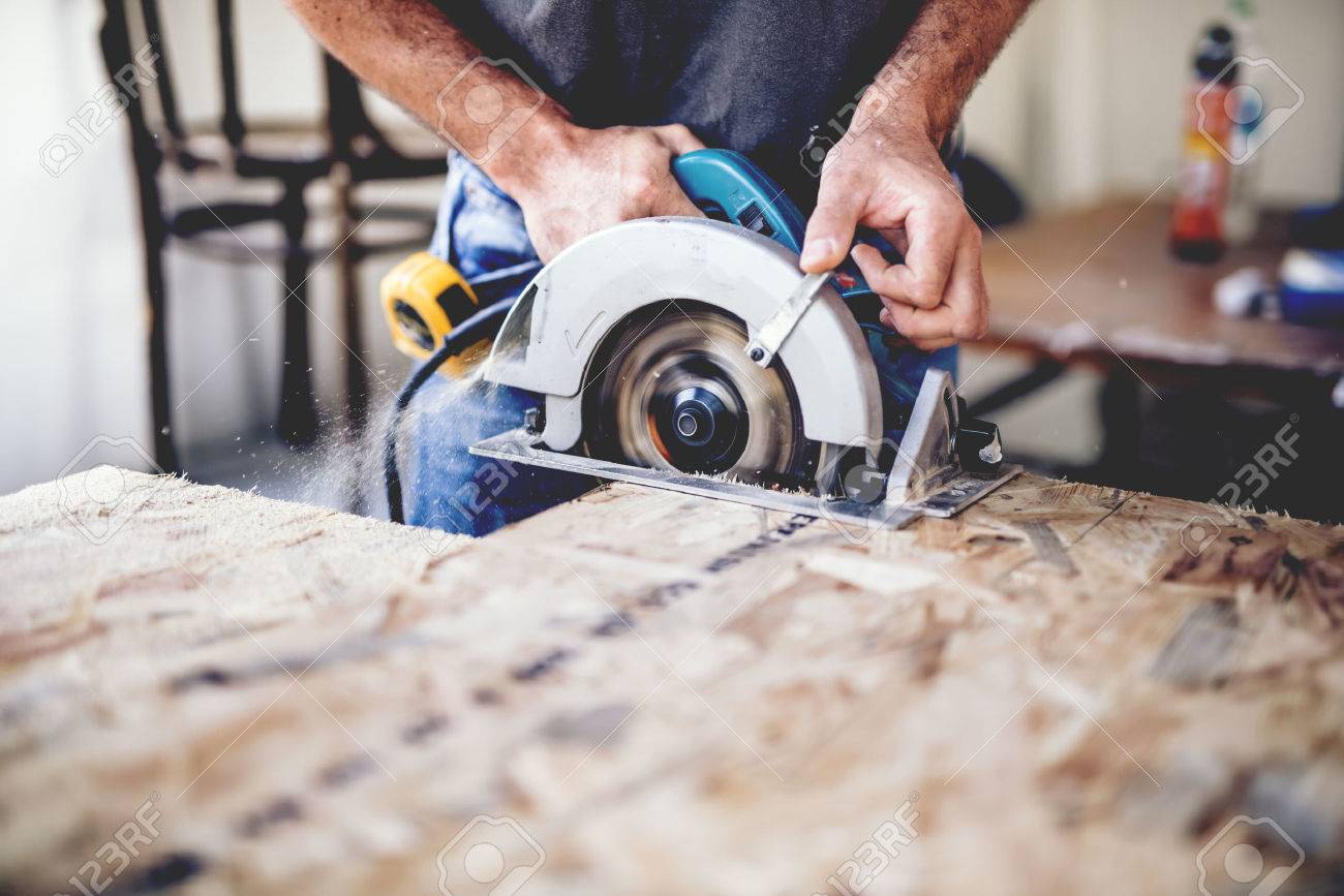 Carpenter using circular saw for cutting wooden boards. Construction details of male worker or handy man with power tools - 70339781 Carpenter using circular saw for cutting wooden boards. Construction details of male worker or handy man with power tools - 70339781