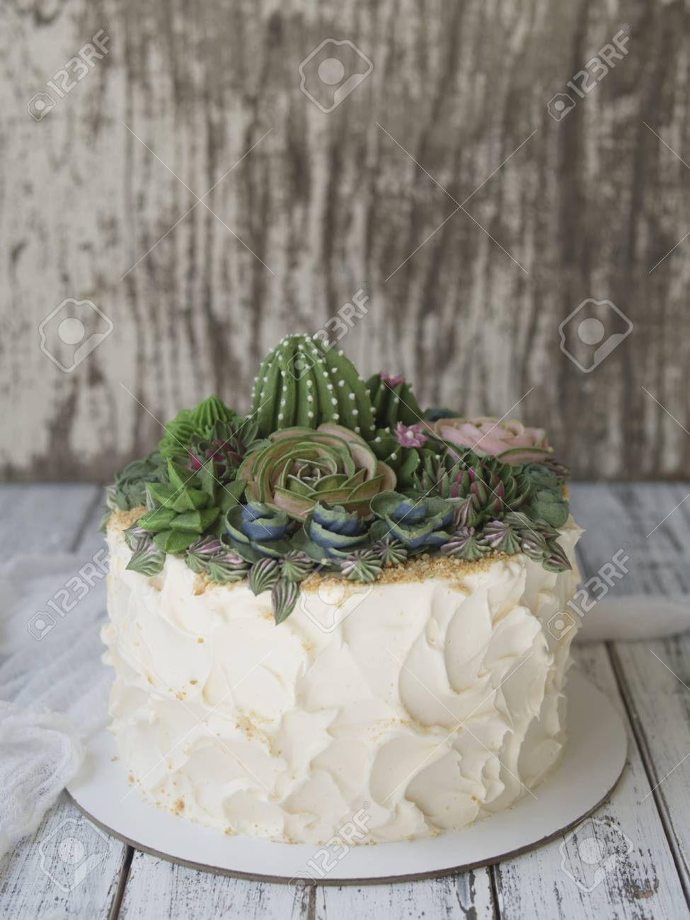 Cake Decorated With Creamy Succulents On A Wooden Background