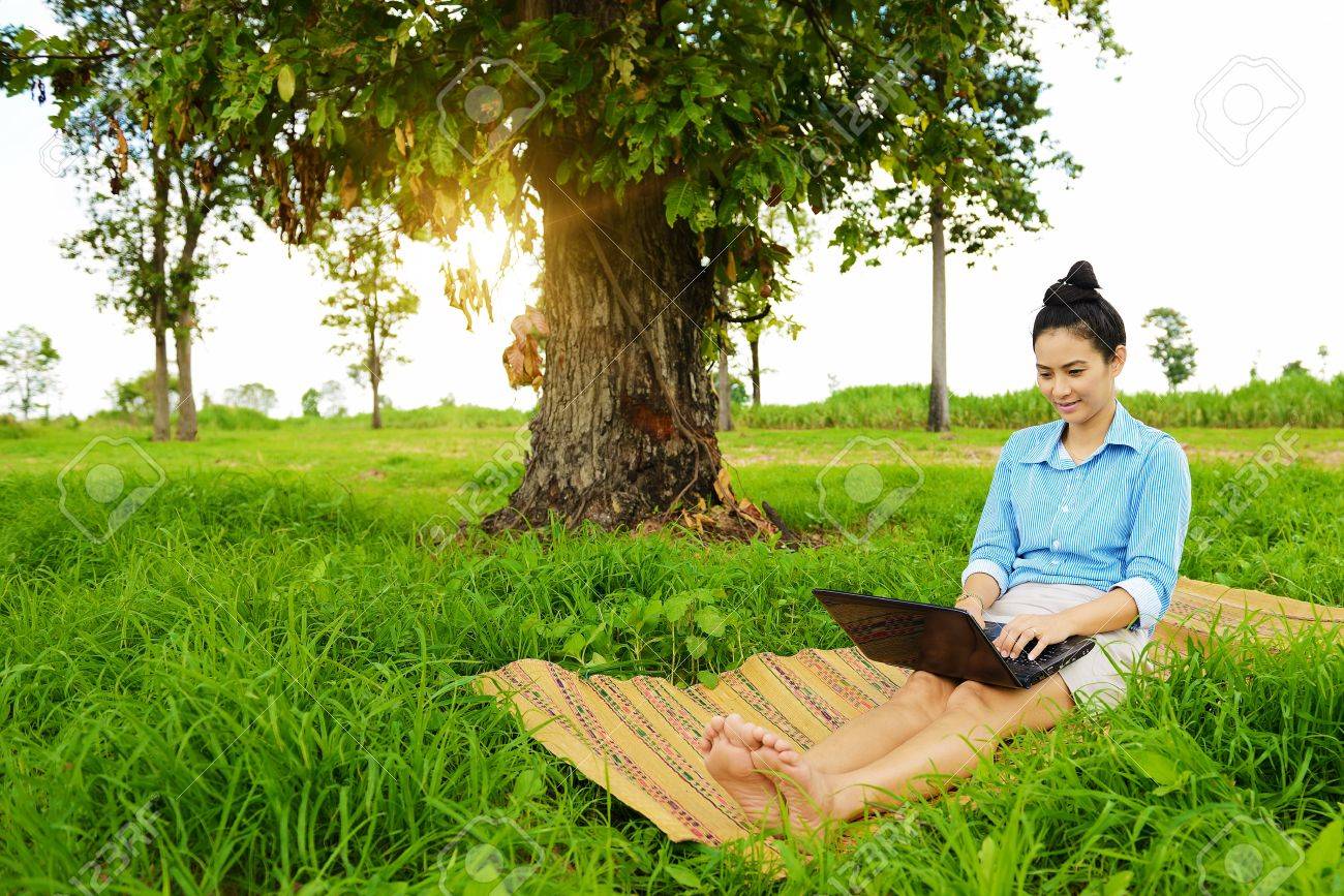 Business woman using laptop in the field - 22159229 Business woman using laptop in the field - 22159229