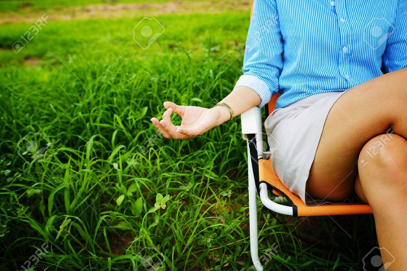 Business woman meditating and making yoga at green field - 22160196 Business woman meditating and making yoga at green field - 22160196