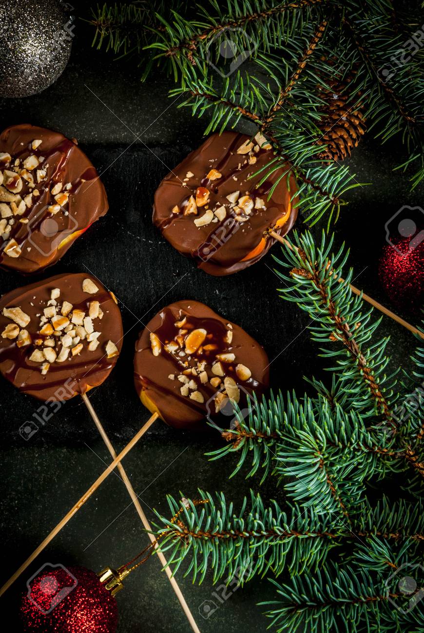 冬のアイデア クリスマスを扱います 子供のためのお菓子 チョコレート キャラメル ナッツとチョコレートのリンゴのスライス 緑の石背景が暗いですが クリスマス ツリーの枝 トップ ビュー の写真素材 画像素材 Image 冬のアイデア クリスマスを扱います 子供のためのお菓子 チョコレート キャラメル ナッツとチョコレートのリンゴのスライス 緑の石背景が暗いですが クリスマス ツリーの枝 トップ ビュー の写真素材 画像素材 Image