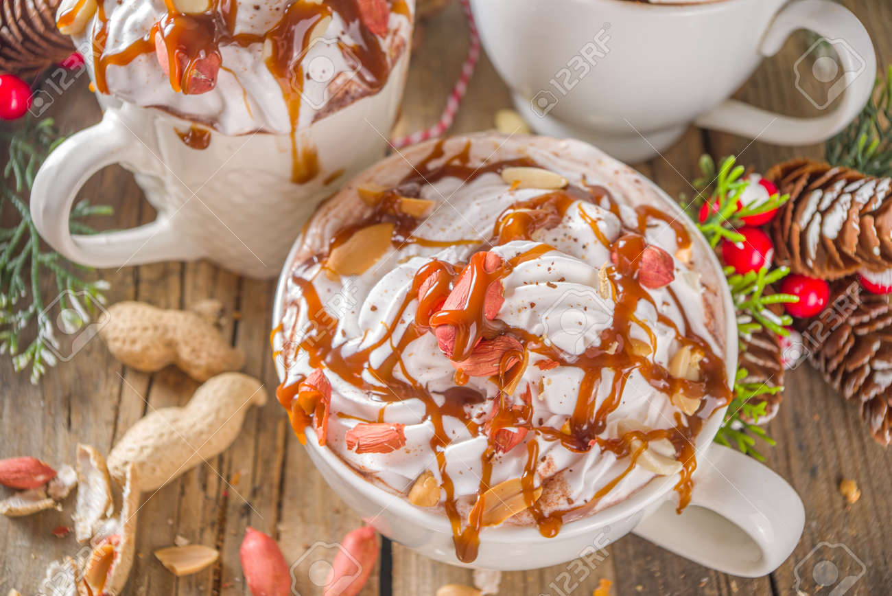 Chocolate Caliente Con Caramelo De Maní Salado. Receta De Chocolate Caliente Keto Y Vegano, Con Malvavisco Y Crema De Coco Batida, Fondo De Madera Con Decoración Navideña Fotos, Retratos, Imágenes Y Fotografía