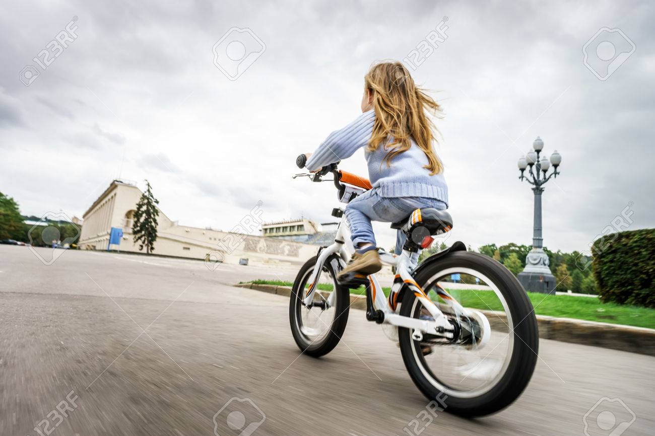 Cute little girl riding fast by bicycle in public park - 31345854 Cute little girl riding fast by bicycle in public park - 31345854