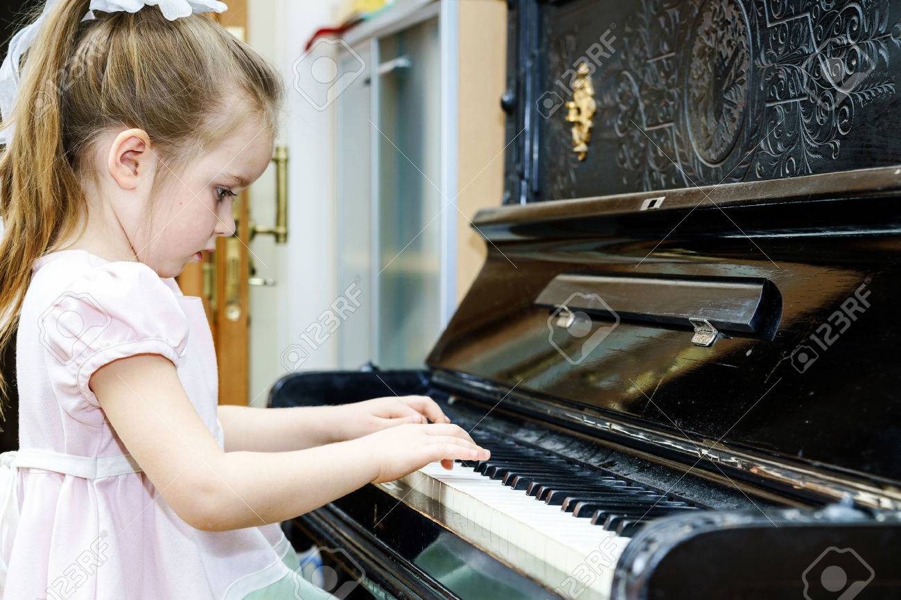 Cute little girl playing old piano at home lesson - 37878509 Cute little girl playing old piano at home lesson - 37878509