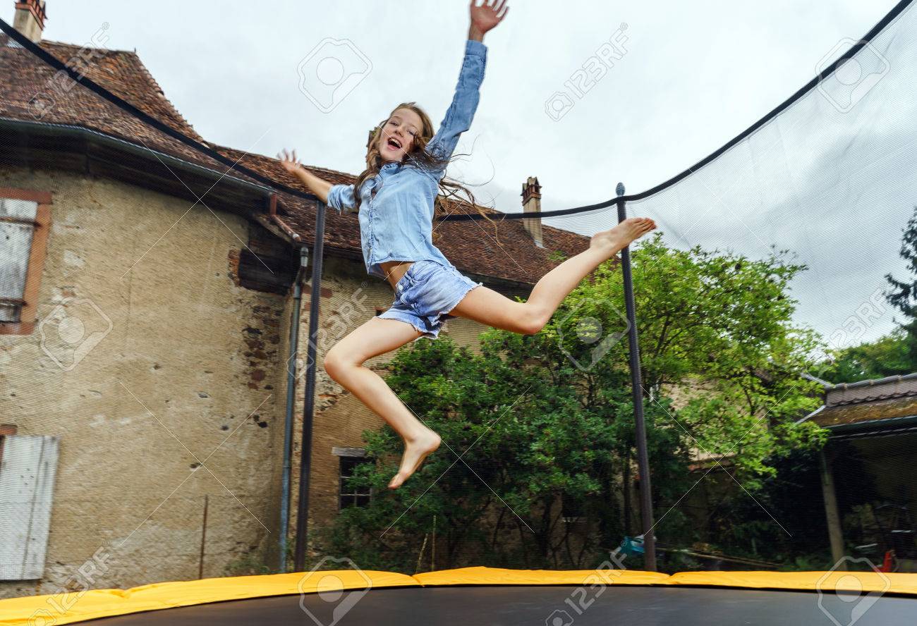 Cute teenage girl jumping on trampoline, childhood concept - 43761475 Cute teenage girl jumping on trampoline, childhood concept - 43761475