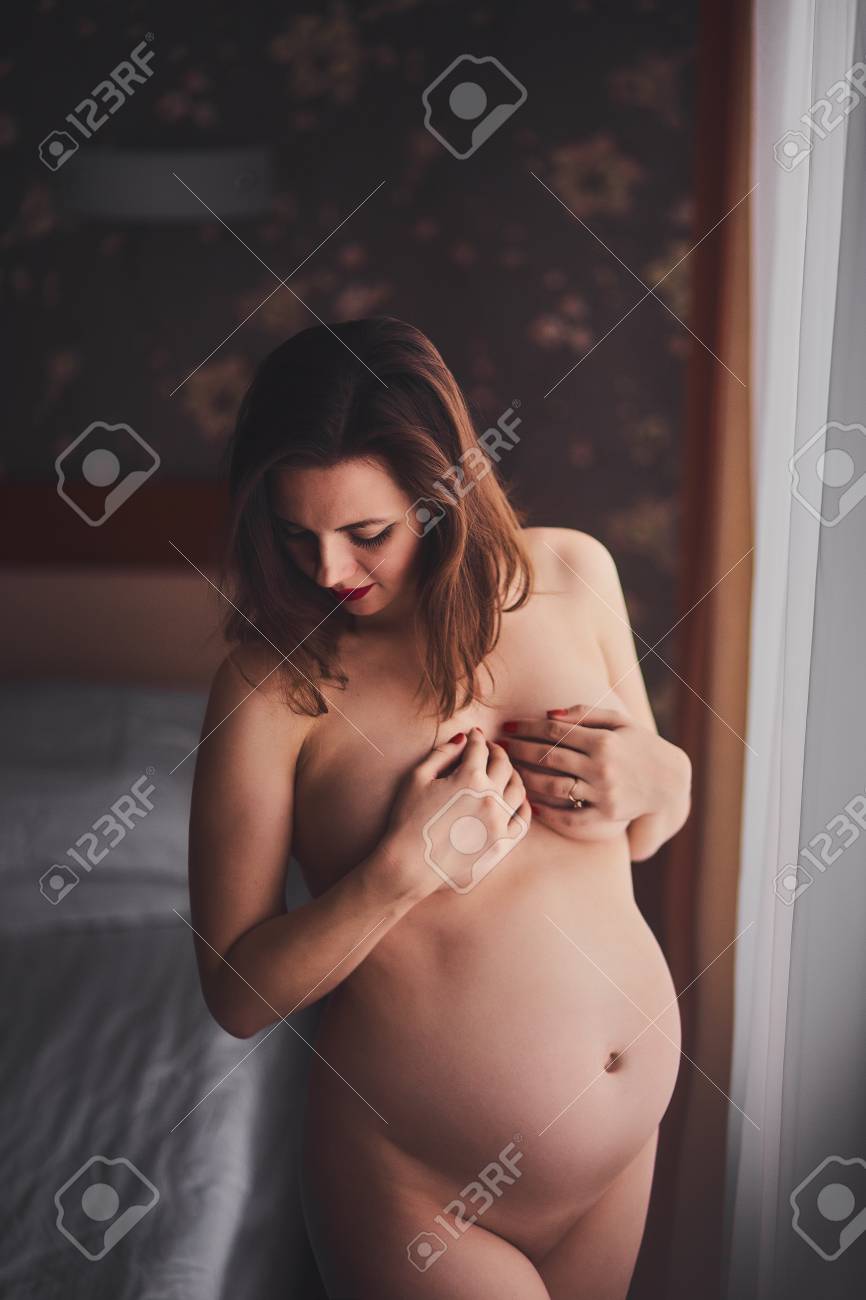 young pregnant nude カーテン付きの大きな窓の近くに性的な裸の若い妊婦。美しいスタイリッシュなヌード妊娠写真。女の子は彼女の手で彼女の胸をカバーの写真素材・画像素材 Image 96430178