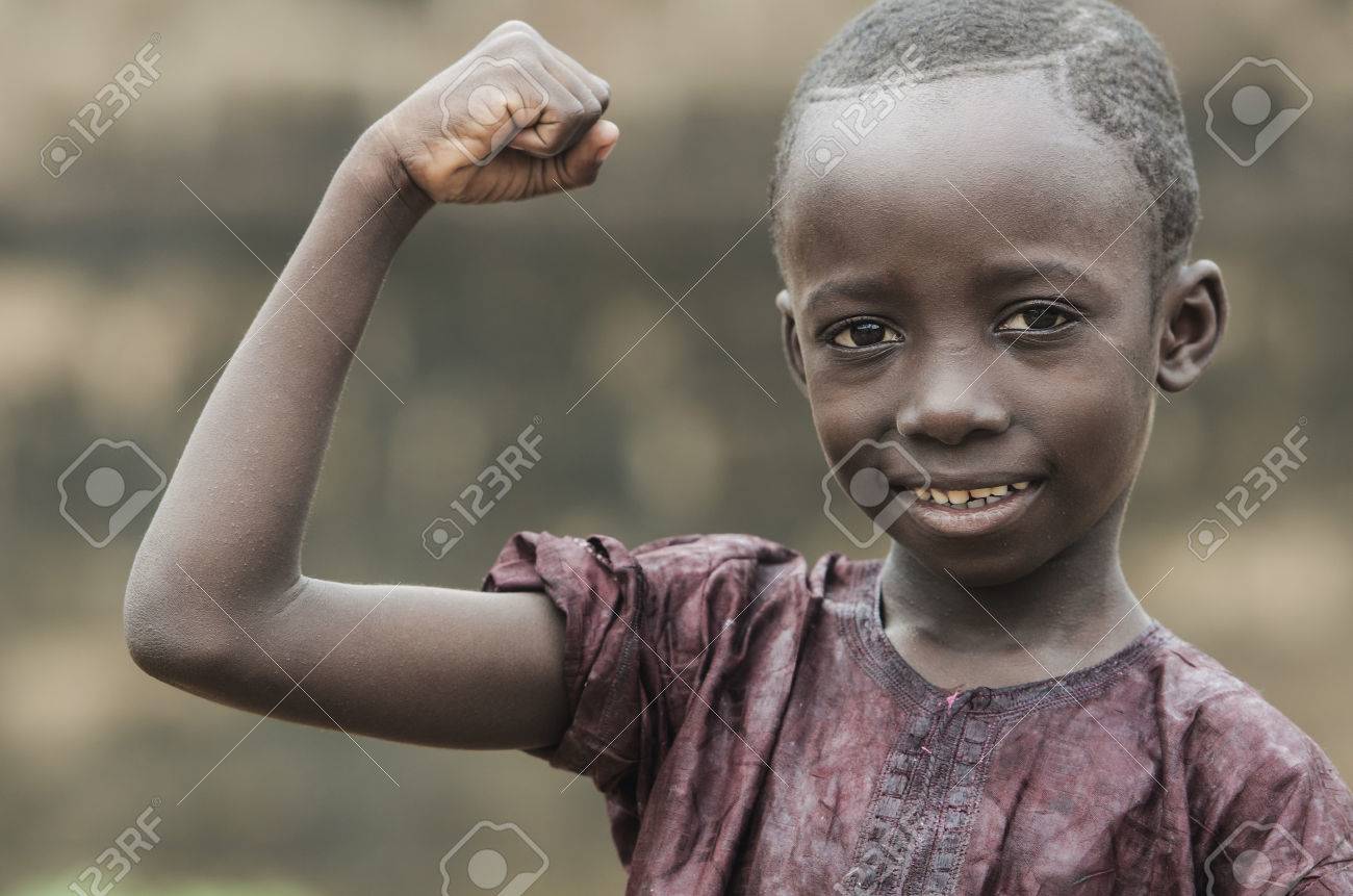 мальчик Маленький Африканский Мальчик Показывает Мышцы И Смотрит На Камеру С Размытым Фоном Фотография, картинки, изображения и сток-фотография без роялти. Image 73133802