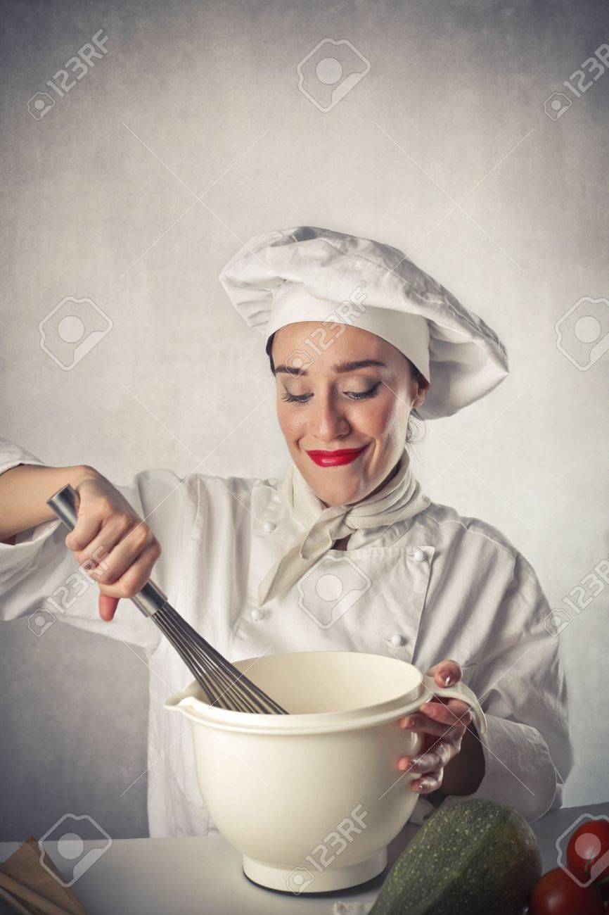 Smiling Female Cook Mixing Some Food Ingredients In A Bowl Stock Photo