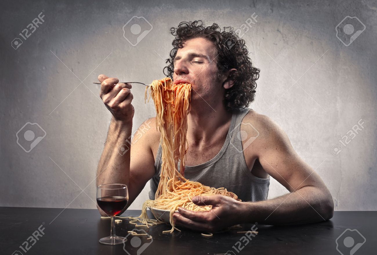 Man gorging of spaghetti with red tomato sauce - 15662618 Man gorging of spaghetti with red tomato sauce - 15662618