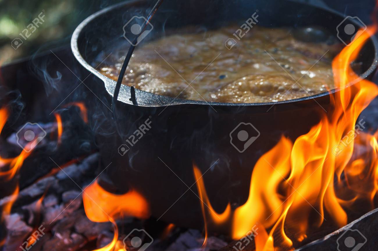 Tourist bowler with food on bonfire, cooking in the hike, outdoor activities. Preparation of pilaf or soup on fire. - 89837934 Tourist bowler with food on bonfire, cooking in the hike, outdoor activities. Preparation of pilaf or soup on fire. - 89837934