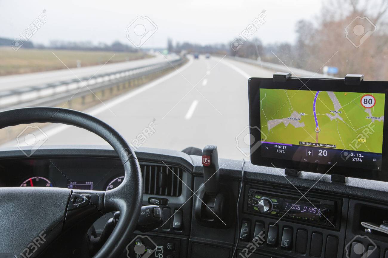 View of highway traffic through the windshield of the truck cab. Navigation is mounted on the dashboard. - 37927057 View of highway traffic through the windshield of the truck cab. Navigation is mounted on the dashboard. - 37927057