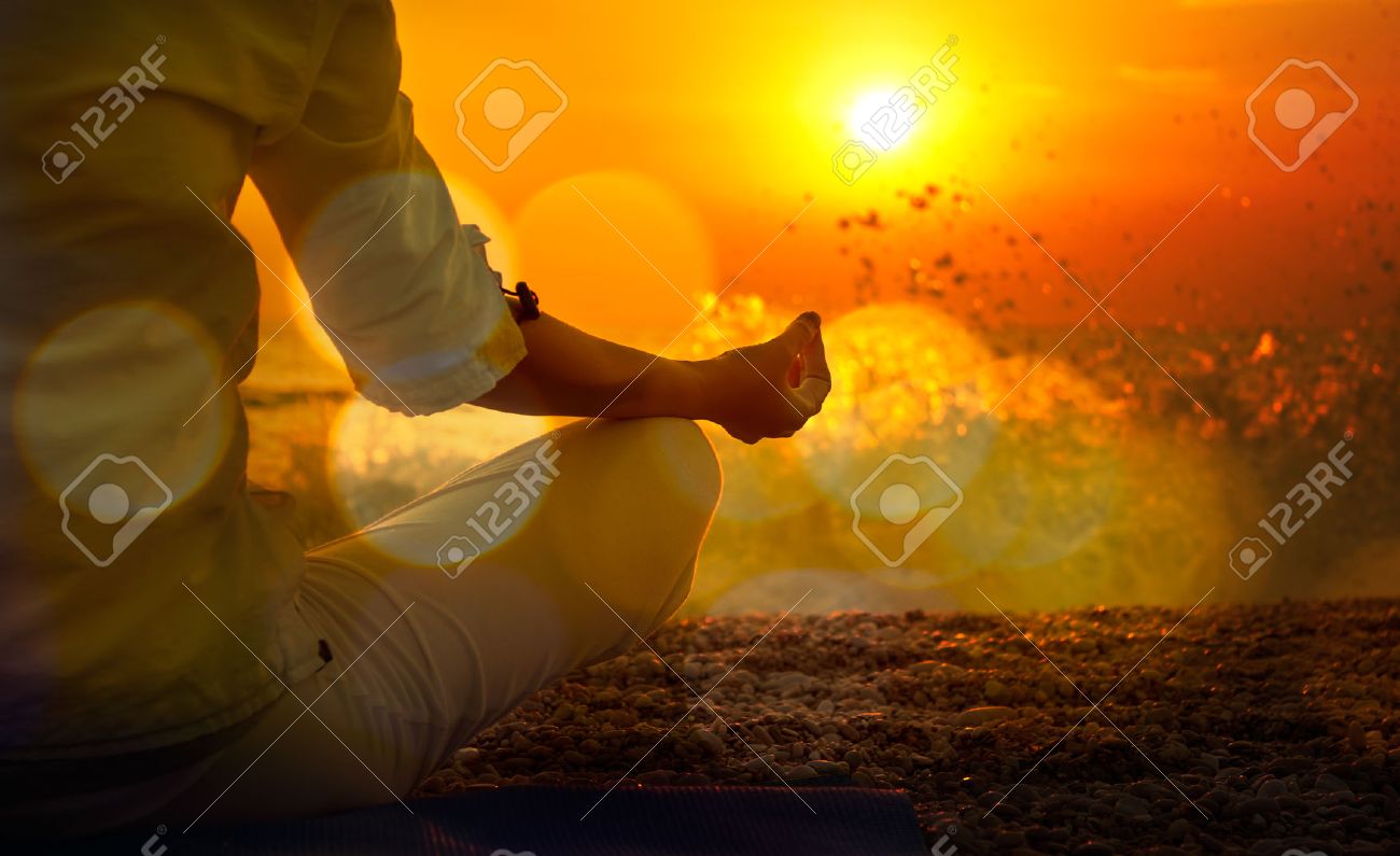 Woman Practicing Yoga by the Sea at Sunset. Beautiful Toned Photo with Golden Bokeh. Healthy Lifestyle Concept. - 28613180 Woman Practicing Yoga by the Sea at Sunset. Beautiful Toned Photo with Golden Bokeh. Healthy Lifestyle Concept. - 28613180