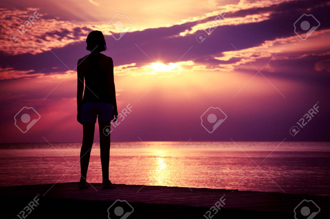 Silhouette of Young Woman Watching Sea Sunset. Breathtaking Nature Background. Toned Photo with Copy Space. - 38534367 Silhouette of Young Woman Watching Sea Sunset. Breathtaking Nature Background. Toned Photo with Copy Space. - 38534367