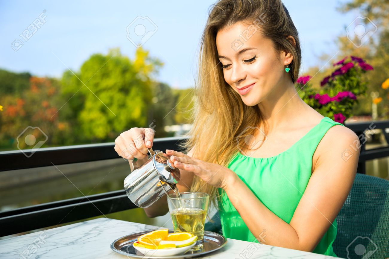 Happy Smiling Woman Making Green Tea Outdoors. Summer Background. Healthy Eating Concept. Shallow Depth of Field. - 39206968 Happy Smiling Woman Making Green Tea Outdoors. Summer Background. Healthy Eating Concept. Shallow Depth of Field. - 39206968