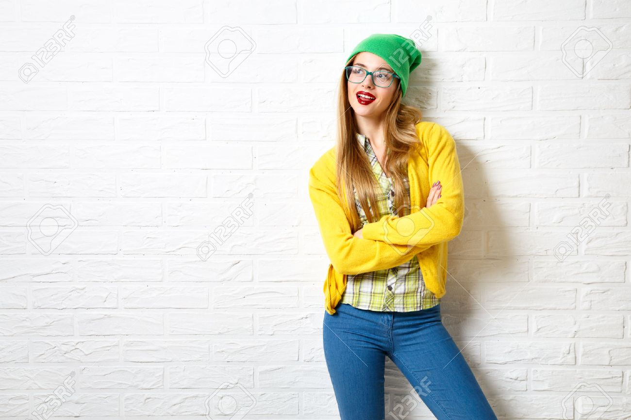 Street Style Hipster Girl at White Brick Wall Background. Trendy Casual Fashion Outfit in Winter. Copy Space. - 48361692 Street Style Hipster Girl at White Brick Wall Background. Trendy Casual Fashion Outfit in Winter. Copy Space. - 48361692