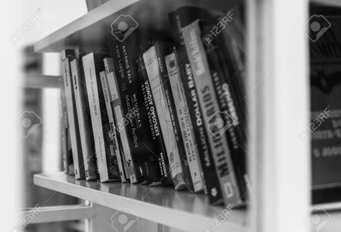 A black and white picture of a group of books sitting on a shelf inside a phone booth. - 132811191 A black and white picture of a group of books sitting on a shelf inside a phone booth. - 132811191