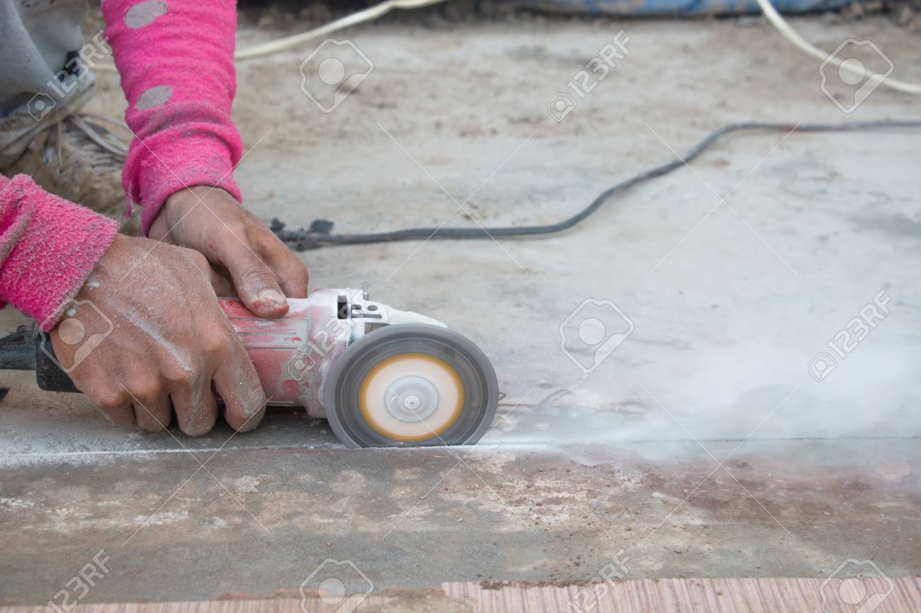 Hand Of Worker Manusing Electric Hand Saw Cutting Cement Floor