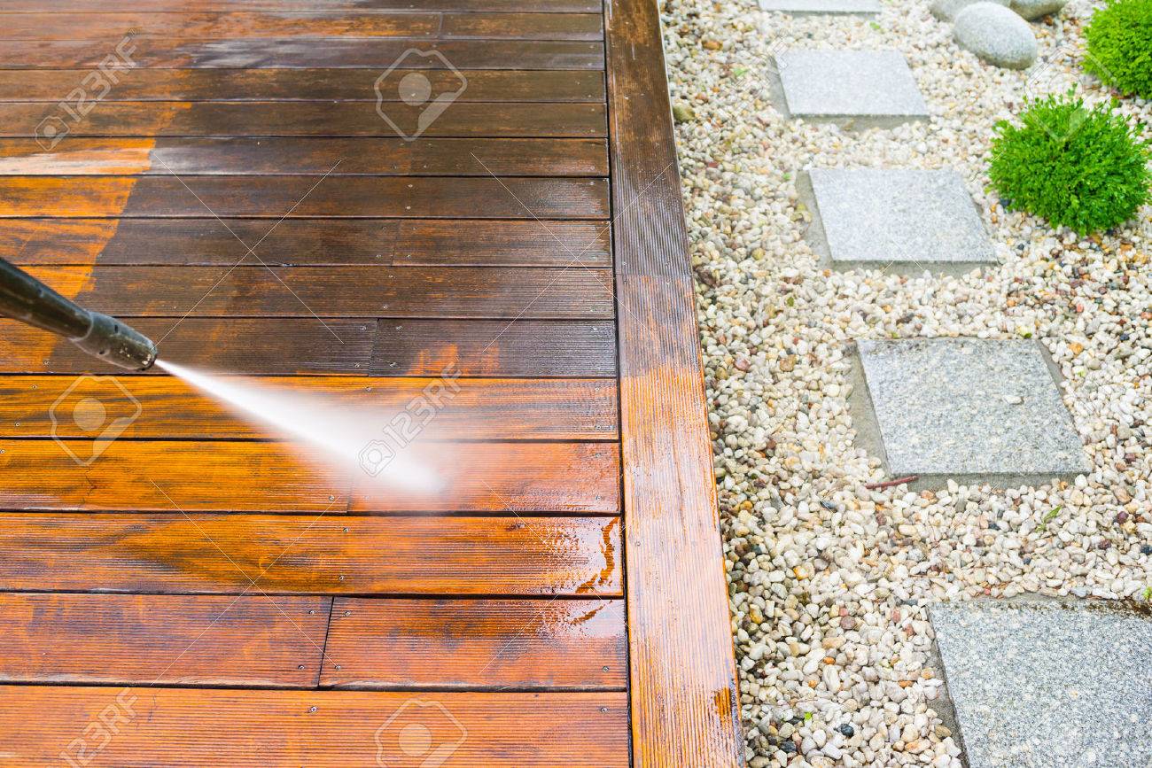 cleaning terrace with a power washer - high water pressure cleaner on wooden terrace surface - 69081084 cleaning terrace with a power washer - high water pressure cleaner on wooden terrace surface - 69081084