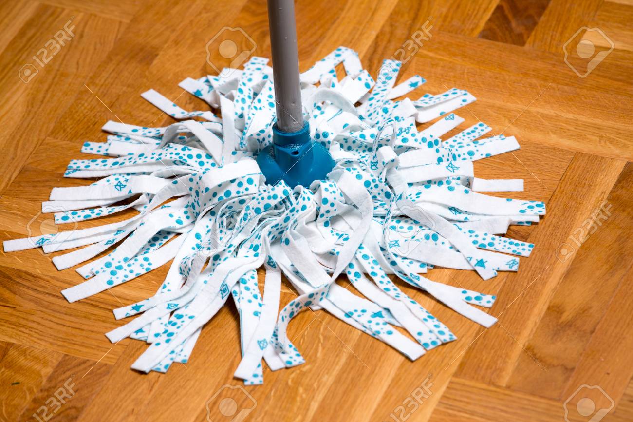 Close Up Of Wet Mop Wiping Parquet Floor Housekeeping Concept