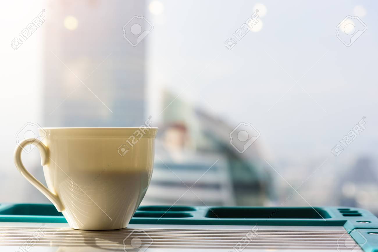 white coffee mug put on the table and have a back view or backgorund