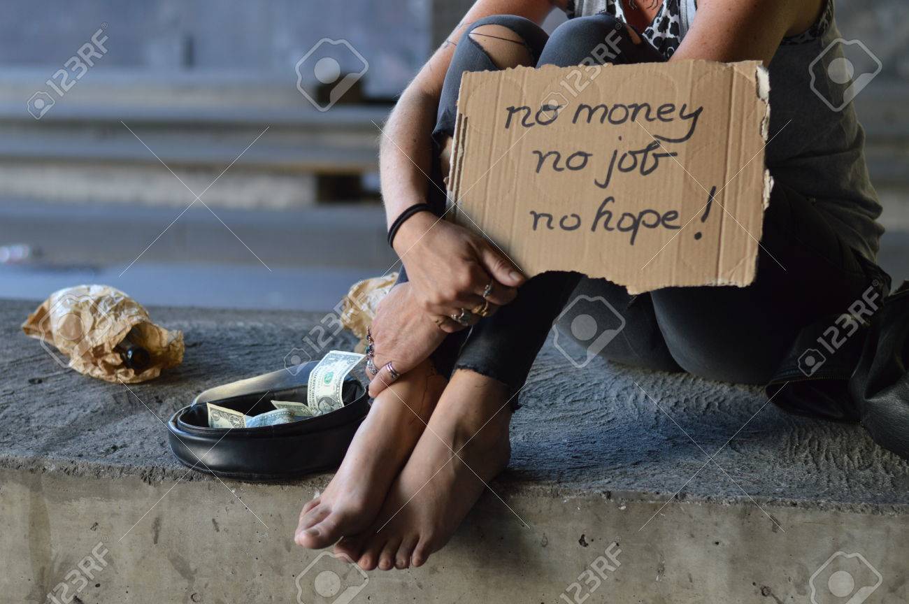 a homeless punk woman begging holding a sign no money no job