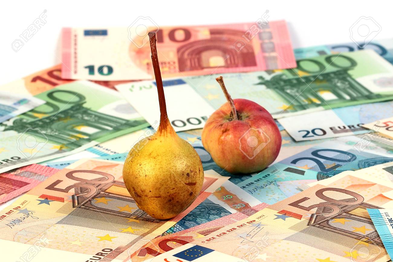 a small pile of paper euro bills and an apple with a pear fruit