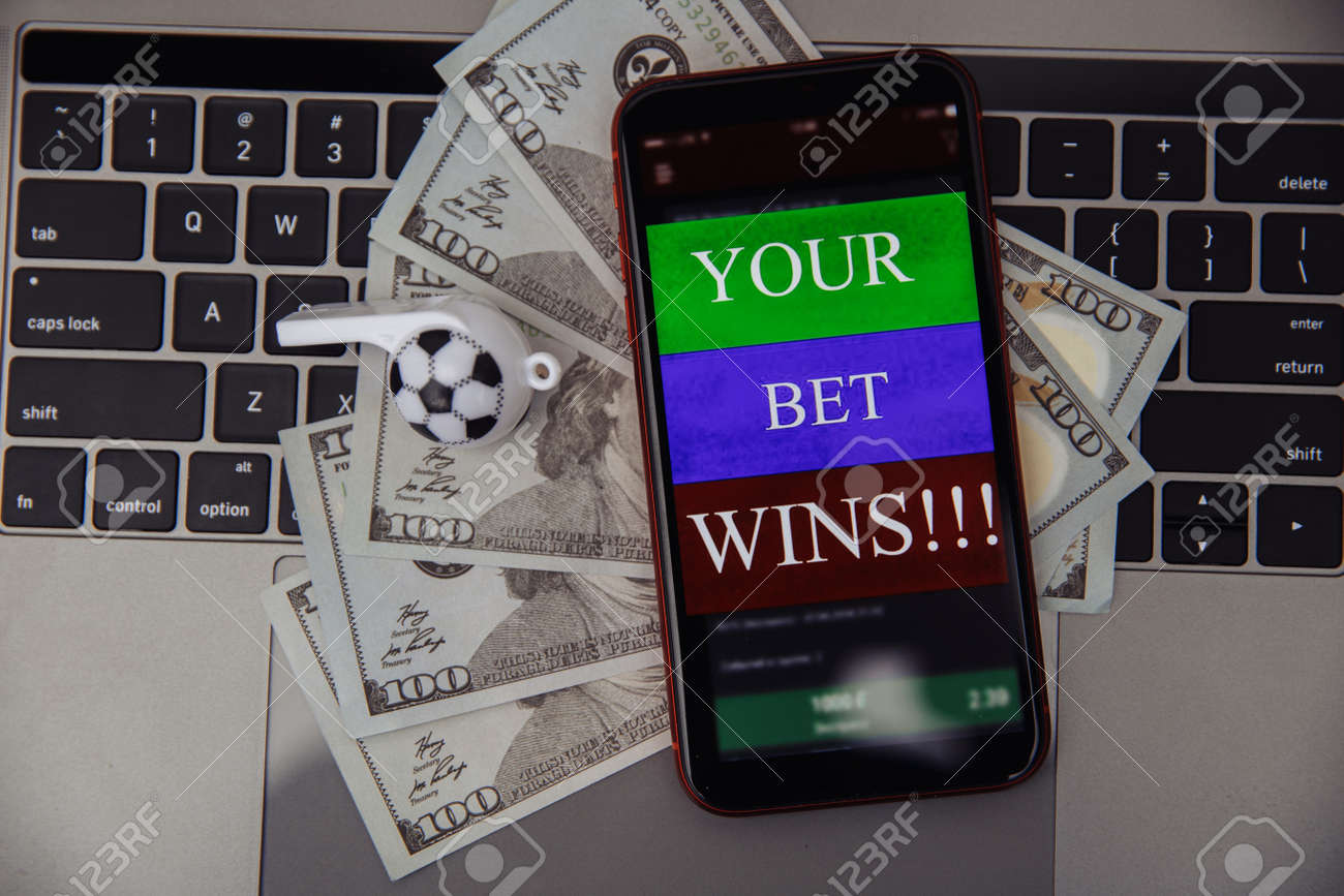 Smartphone With Online Betting Application, Dollar Bills And Soccer Whistle On A Laptop. Gambling Concept Stock Photo, Picture And Royalty Free Image. Image 163835141.