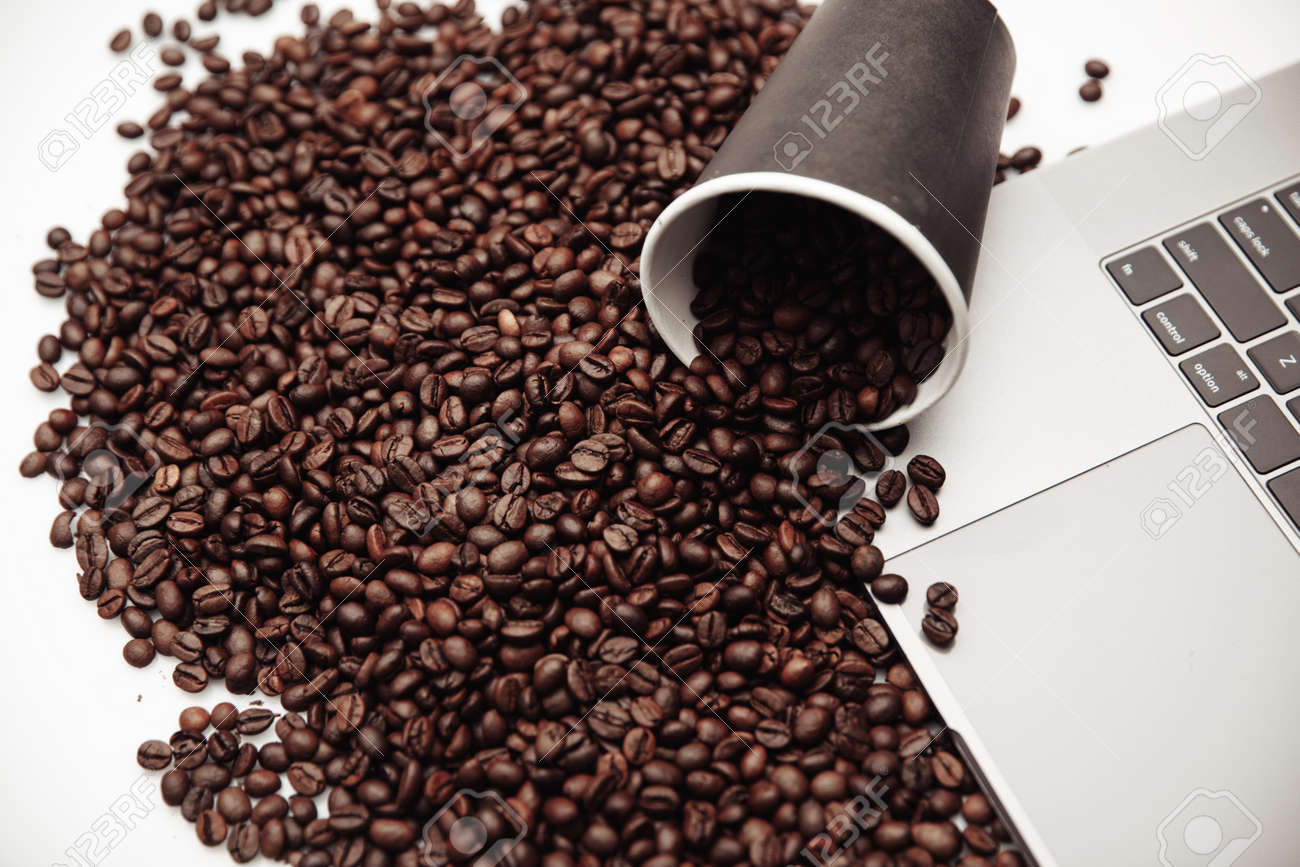 A cup of coffee on keyboard and coffee beans - 169820850 A cup of coffee on keyboard and coffee beans - 169820850
