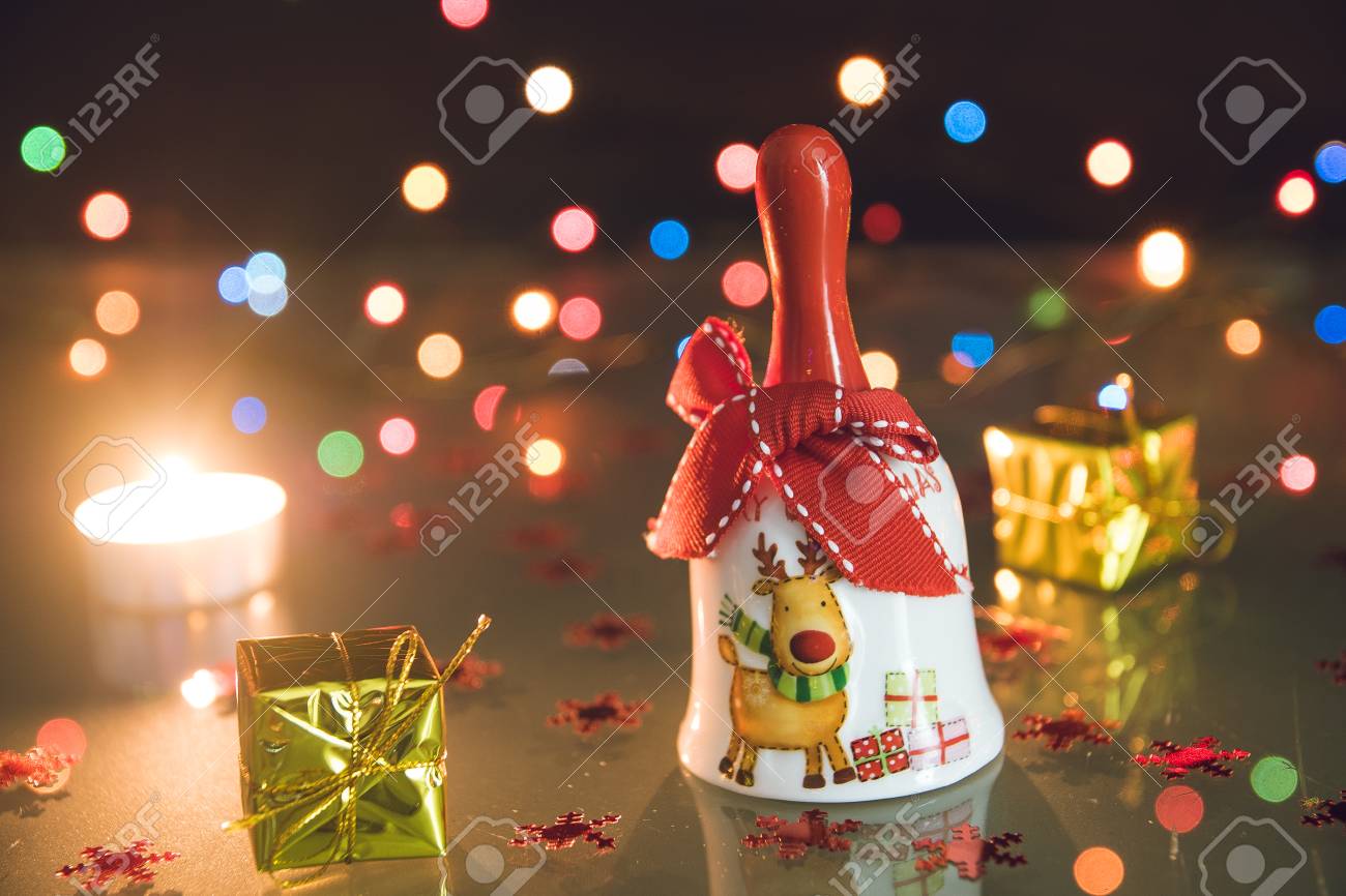 Regali Natale Piccoli.Immagini Stock Campana Di Natale Piccoli Regali E Candele Luce Del Te Sulle Bokeh Sfondo Nero Image 68992795