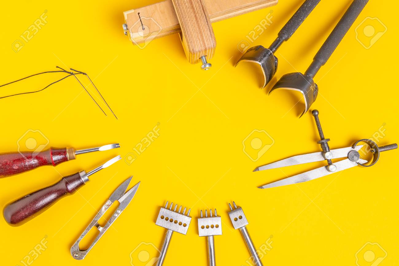 Leather craft tools on a yellow background. Handmade theme - 121046889 Leather craft tools on a yellow background. Handmade theme - 121046889