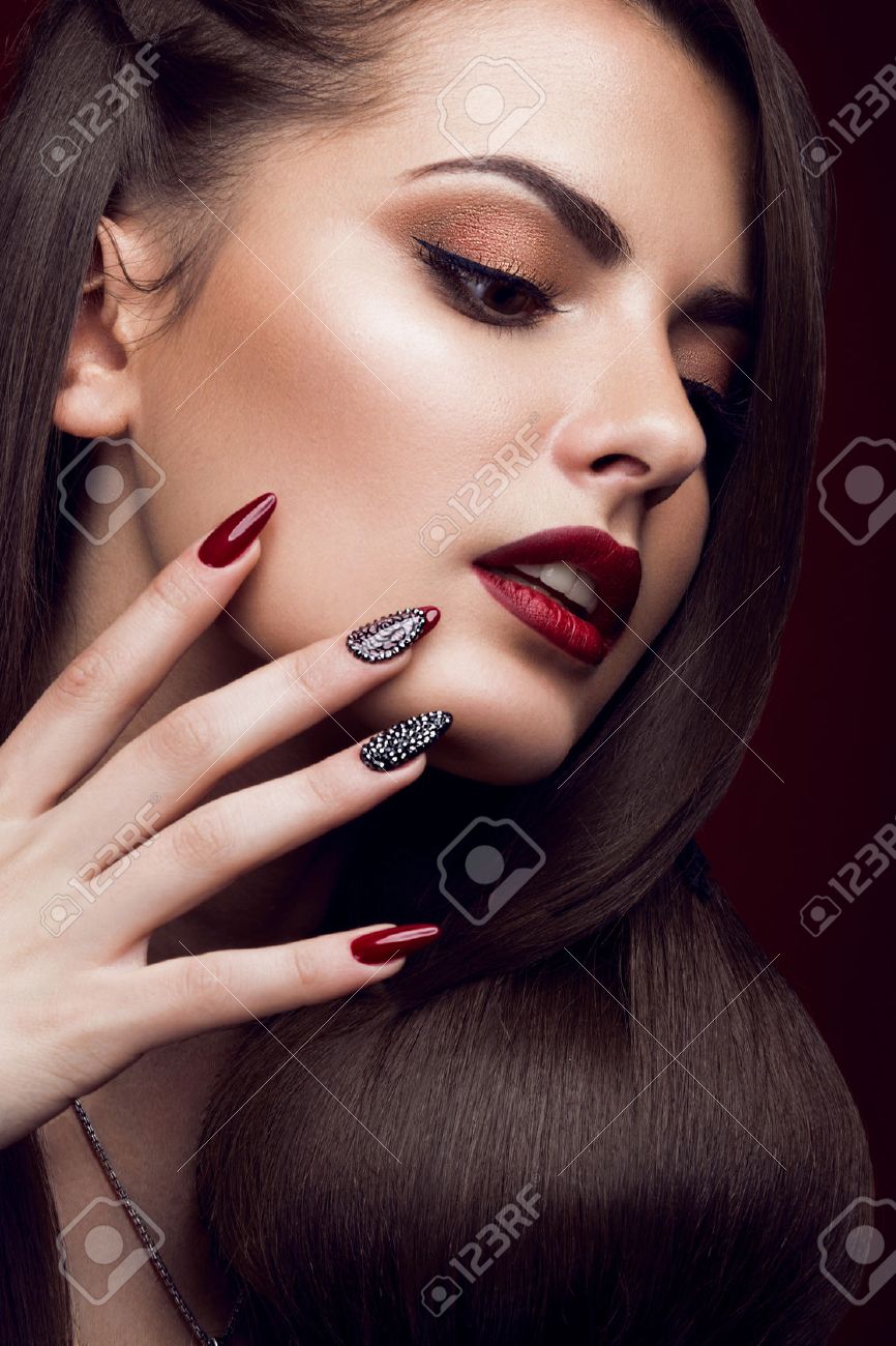 Pretty girl with unusual hairstyle, bright makeup, red lips and manicure design. Beauty face. Art nails. Picture taken in the studio on a red background. - 50899024 Pretty girl with unusual hairstyle, bright makeup, red lips and manicure design. Beauty face. Art nails. Picture taken in the studio on a red background. - 50899024