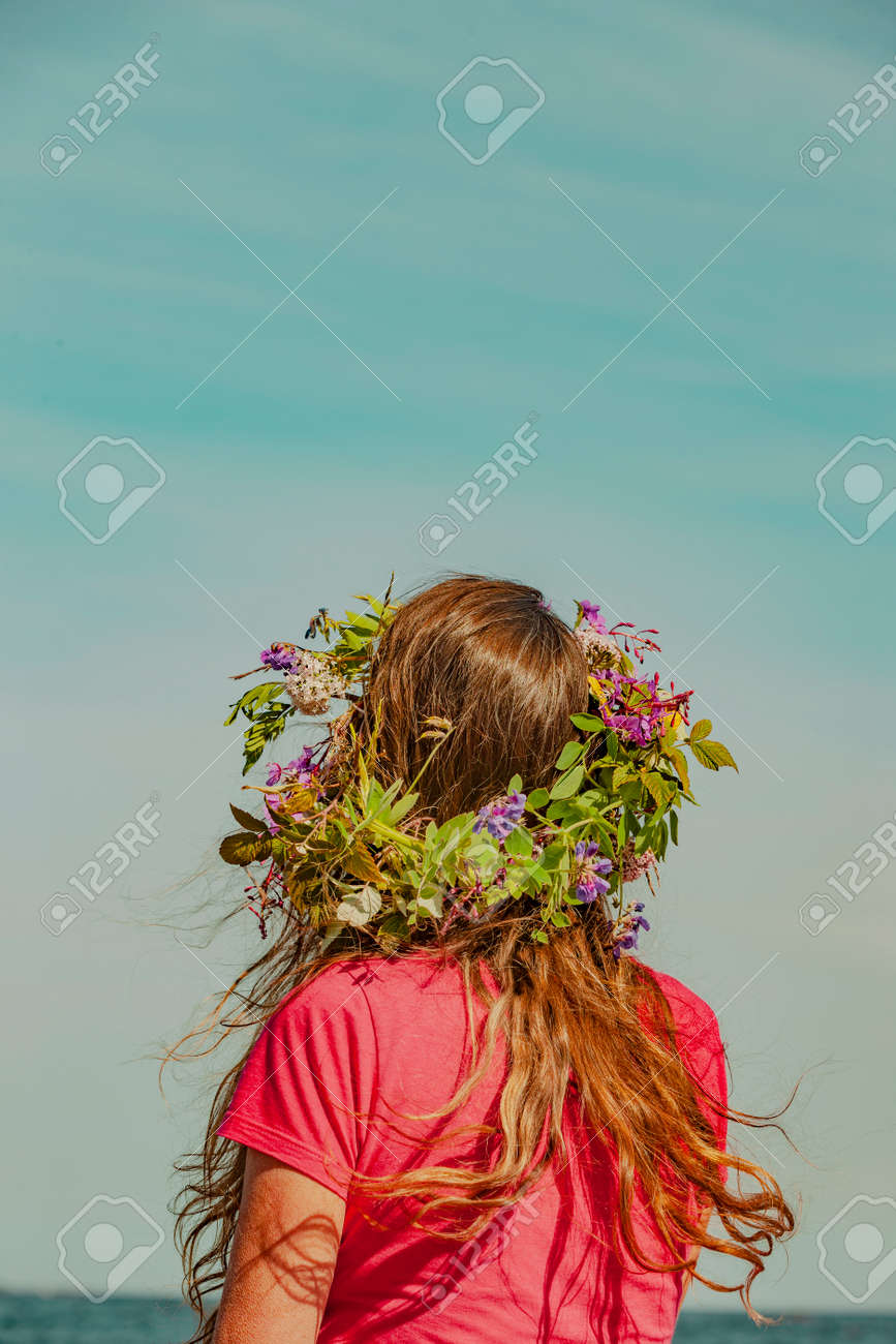 Brunette woman with wreath of flowers in Sweden - 169244995 Brunette woman with wreath of flowers in Sweden - 169244995