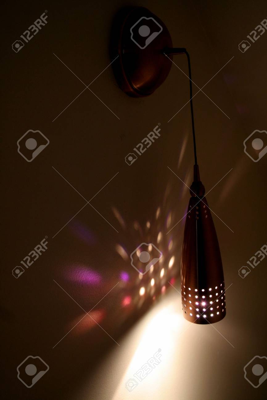 Una Luz De Pared Colgante Que Brilla Un Patron En Una Pared Fotos